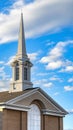 Vertical Exterior of a beautiful church with a white steeple against cloudy blue sky Royalty Free Stock Photo