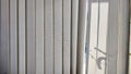 Vertical fabric white blinds on the window with light and shadow from the sun. Background and texture. Abstract pattern Royalty Free Stock Photo