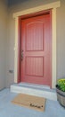 Vertical Facade of home with red front door and wooden shutters on the sliding window