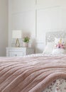 Vertical Feminine bedroom with floral bedsheet and pink blanket on the bed against wall Royalty Free Stock Photo