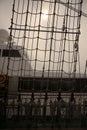 A vertical filled frame wallpaper photo of a net on a mast of a tall ship with plaited ropes and forming unordinary lines and