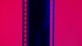 Vertical film strip on a red background, close up. 35mm film slide frame. Long, retro film strip frame. Copy space. Royalty Free Stock Photo