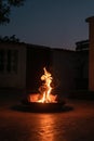 Vertical of a fire pit stuffed with wood burning in the backyard of a house on a summer night. Royalty Free Stock Photo
