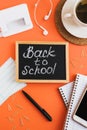 Vertical flat lay with blackboard with handwritten text `Back to School`