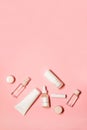 Vertical flat lay shot with a copy space on a pink background with skincare goods: hand cream, deodorant, lipstick, serum, Royalty Free Stock Photo