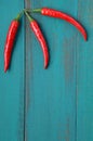 Vertical flat lay view of three hot red chili peppers