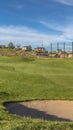 Vertical Focus on a sand trap surrounded by short green grasses at a sunny golf course Royalty Free Stock Photo