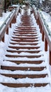 Vertical Focus on stairway that goes up a snowy hill with residential homes in winter