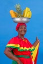 Vertical footage of a Palenquera holding bowl of fruits above head, dressed with colorful clothes