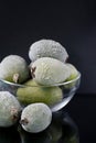 Vertical format. Composition of frozen feijoas in bowl on black background. Source Royalty Free Stock Photo