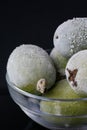 Vertical format of frost feijoas in translucent bowl on black background. Saving Royalty Free Stock Photo