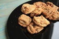 Gourmet cookies on a black plate. On green rustic wood