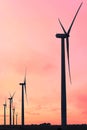 Vertical format of silhouettes of wind turbines on a farm in Iowa on a sunset sky