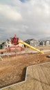 Vertical frame Childrens playground against snow capped mountain and cloudy sky in winter