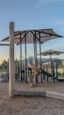 Vertical frame Childrens playground at a park with swings slides and umbrellas viewed at sunset Royalty Free Stock Photo