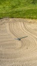 Vertical frame Close up of golf course sand bunker with a circular pattern created by the rake