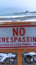 Vertical frame Close up of No Trespassing signage with snowy Utah Lake background in winter Royalty Free Stock Photo