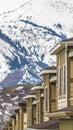 Vertical frame Close up of upper storey of homes against snow blanketed mountain in winter