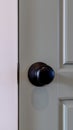 Vertical frame Closed gray wooden door with round black door handle inside of home Royalty Free Stock Photo
