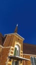Vertical frame Facade of a church in Provo Utah with brick wall arched windows and steeple