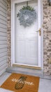 Vertical frame Facade of home with a leafy wreath hanging between the glass and wooden door Royalty Free Stock Photo