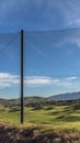 Vertical frame Fence with golf course homes and mountain against blue sky on the other side Royalty Free Stock Photo