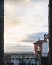 Vertical frame in a frame shot of a balcony with concrete balusters and a cloudy horizon