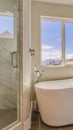 Vertical frame Glossy bathtub and separate shower inside the sunlit bathroom of a new house