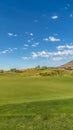 Vertical frame Golf course with vivid green fairway under blue sky and clouds on a sunny day Royalty Free Stock Photo