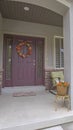 Vertical frame Home facade with rocking chairs and potted flowers on the concrete porch Royalty Free Stock Photo