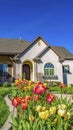 Vertical frame Landscaped yard of a home with pathway stairs tulips trees and grasses