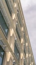 Vertical frame Modern office building exterior viewed against cloudy sky on a sunny day Royalty Free Stock Photo