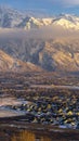 Vertical frame Snowy Mount Timpanogos and charming homes against cloudy blue sky at sunset