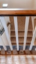 Vertical frame U shaped staircase with white baluster brown handrail and carpet on treads