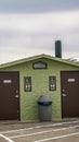 Vertical frame Unisex public restroom against lake snowy mountain and cloudy sky in winter Royalty Free Stock Photo