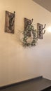 Vertical frame Wood cabinets and iron hooks against the beige wall of a home with white floor