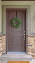 Vertical Front door of suburban home with green wreath Royalty Free Stock Photo