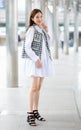 Vertical front view full-length body portrait of cute smiling young adult Asian woman with brown hair, trendy modern clothes and Royalty Free Stock Photo