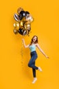 Vertical full body photo of lady having best time with air ballons in hands wear casual outfit isolated yellow