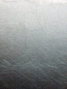 A vertical full frame close-up shot of a silver gray synthetic leather texture with a grainy surface and a gradient Royalty Free Stock Photo