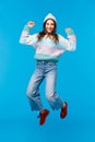 Vertical full-length portrait super happy girl jumping from amazement, celebrating new year, christmas party, enjoying