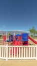 Vertical Fun colorful childrens playground overlooking lake snowy mountain and blue sky
