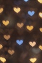 Vertical golden bokeh hearts background.