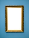 Vertical golden wooden picture frame on blue wall