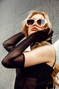 Vertical gorgeous and mysterious blond woman with sunglasses, look like actress celebrity, standing outdoors near club Royalty Free Stock Photo