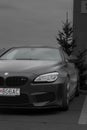 Vertical grayscale of a BMW parked outdoors