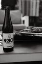 Vertical grayscale closeup of Noice beer on a garden table Royalty Free Stock Photo