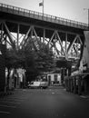 Vertical grayscale of an empty street with a large bridge on it in Vancouver, Canada