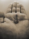 Vertical grayscale of a metal key in the palm of a person on an isolated background