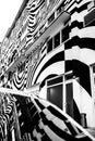 Vertical grayscale shot of an abstract building facade painted in black and white curvy stripes